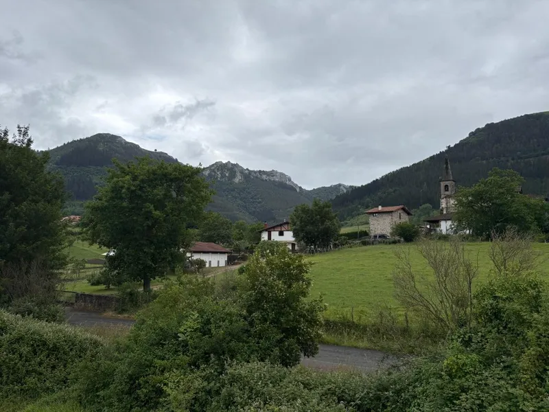 Pueblo con casas de teja y campanario en un valle montañoso